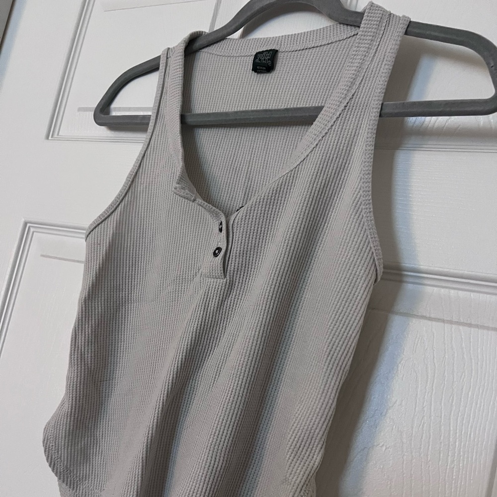Cream colored tank with buttons on front